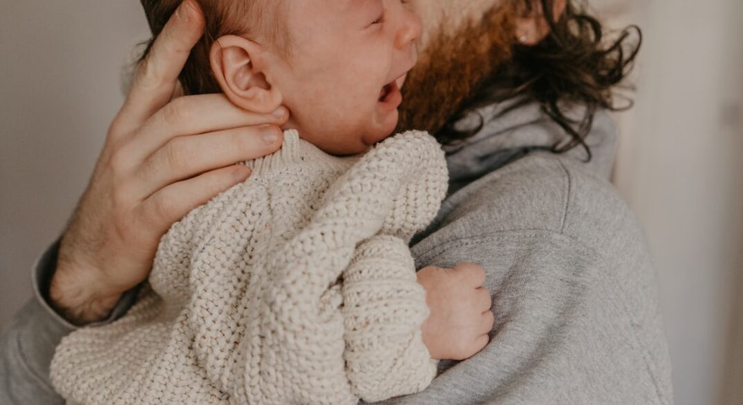 a man holding a baby in his arms